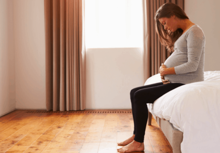Pregnant Woman Sitting on Bed